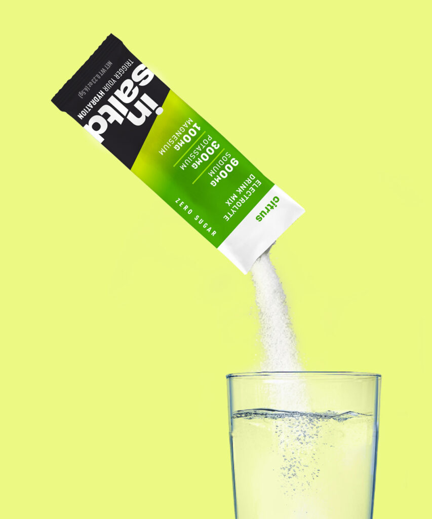 Insaltd Citrus hydration drink mix pouring into glass of water.
